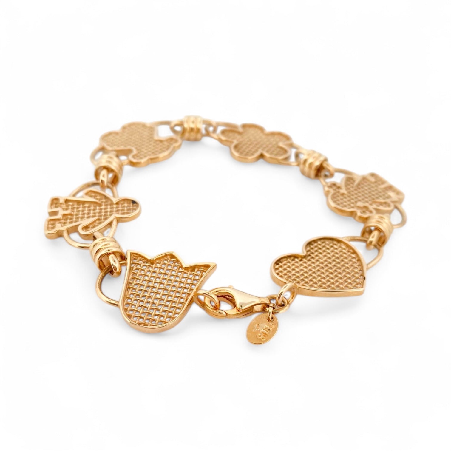 Pulsera original de Tous calada de Oro de 18kt y piezas con motivos de tulipán, osito flor, niña y corazón y cierre tipo mosquetón. La pulsera mide 17,8cm y las piezas 15,86mm. Esta pieza ha sido restaurada en nuestro taller de Barcelona. Compro Oro al mejor precio, joyería segunda mano Barcelona, diseño y transformación de joyas.