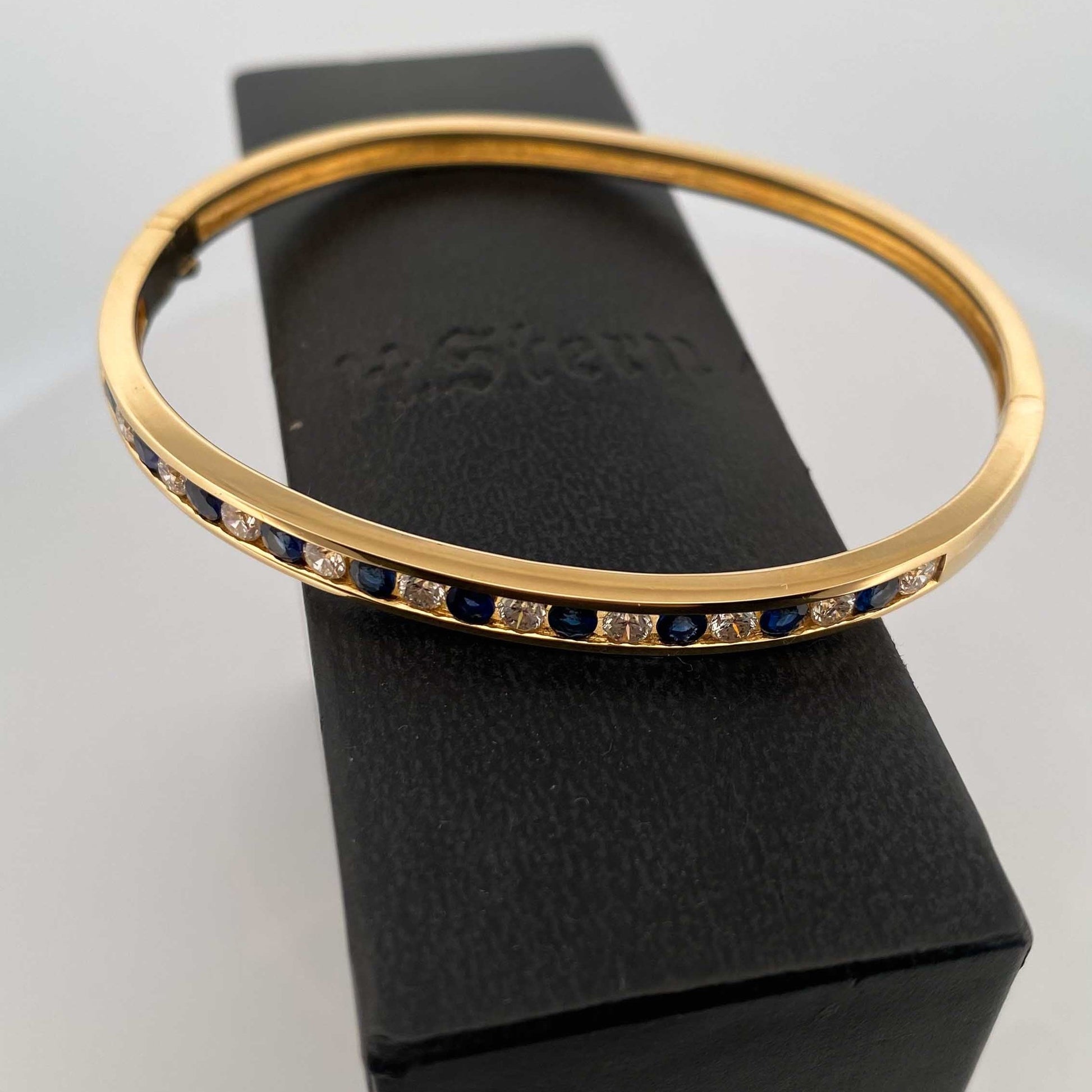 Pulsera esclava de Oro amarillo de 18kt con zafiros y diamantes. Esta preciosa pulsera rígida dispone de cierre de cajón. Joyas de segunda mano en Barcelona, compro oro y joyas al mejor precio. Joyería Compro Oro Barcelona, el mejor precio por tu oro y por joyas de segunda mano.