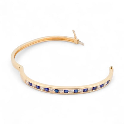 Pulsera esclava de Oro amarillo de 18kt con zafiros y diamantes. Esta preciosa pulsera rígida dispone de cierre de cajón. Joyas de segunda mano en Barcelona, compro oro y joyas al mejor precio. Joyería Compro Oro Barcelona, el mejor precio por tu oro y por joyas de segunda mano.
