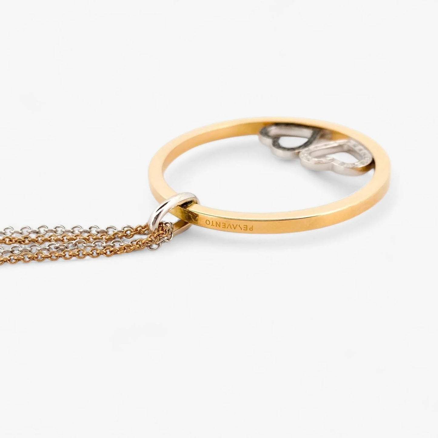 Collar de la firma Pesavento en oro blanco y amarillo de 18kt con circunferencia y dos corazones en su interior. Collar con diamantes negros y blancos.