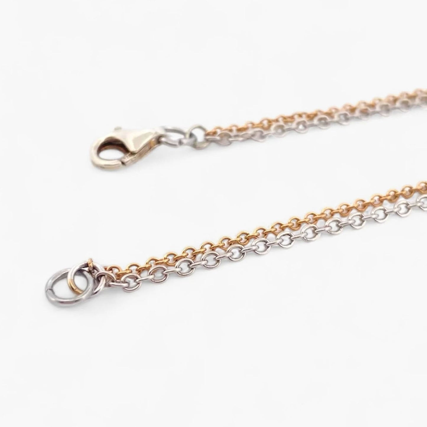 Collar de la firma Pesavento en oro blanco y amarillo de 18kt con circunferencia y dos corazones en su interior. Collar con diamantes negros y blancos.