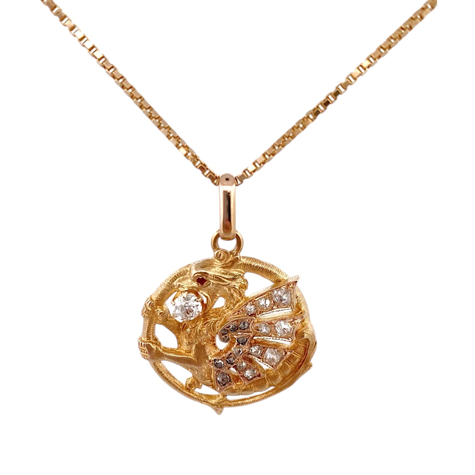 Exclusivo colgante antiguo de oro amarillo de 18kt destaca por su diseño artesanal en forma de dragón, símbolo de fuerza y protección. Adornado con un diamante central de 3mm y ojo de rubí y 18 diamantes talla antigua en sus alas. Una pieza vintage y única para los amantes de este ser mitológico.