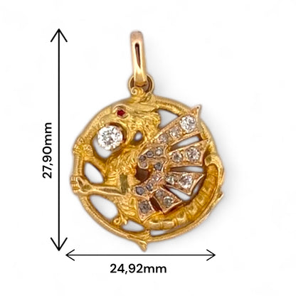 Exclusivo colgante antiguo de oro amarillo de 18kt destaca por su diseño artesanal en forma de dragón, símbolo de fuerza y protección. Adornado con un diamante central de 3mm y ojo de rubí y 18 diamantes talla antigua en sus alas. Una pieza vintage y única para los amantes de este ser mitológico.