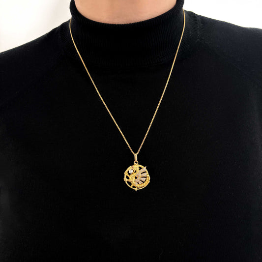 Exclusivo colgante antiguo de oro amarillo de 18kt destaca por su diseño artesanal en forma de dragón, símbolo de fuerza y protección. Adornado con un diamante central de 3mm y ojo de rubí y 18 diamantes talla antigua en sus alas. Una pieza vintage y única para los amantes de este ser mitológico.