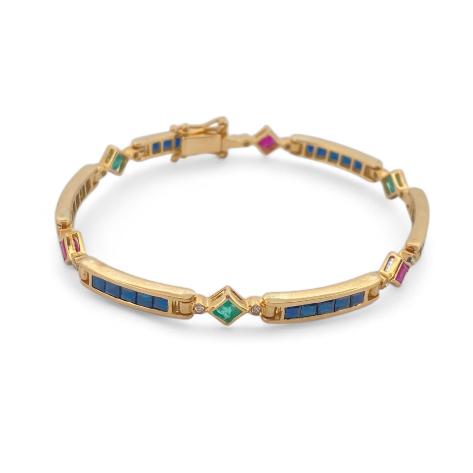 Pulsera semirígida de oro de 18kt con 3 rubíes, 3 esmeraldas y 30 zafiros azules talla princesa. Esta preciosa pulsera vintage dispone de cierre cajón y doble cierre de seguridad. Pesa 13,89g y mide 19cm.