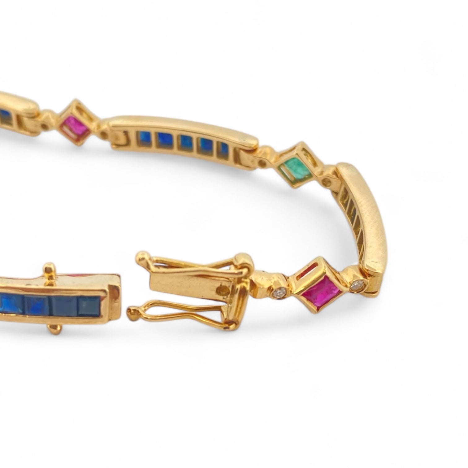 Pulsera semirígida de oro de 18kt con 3 rubíes, 3 esmeraldas y 30 zafiros azules talla princesa. Esta preciosa pulsera vintage dispone de cierre cajón y doble cierre de seguridad. Pesa 13,89g y mide 19cm.
