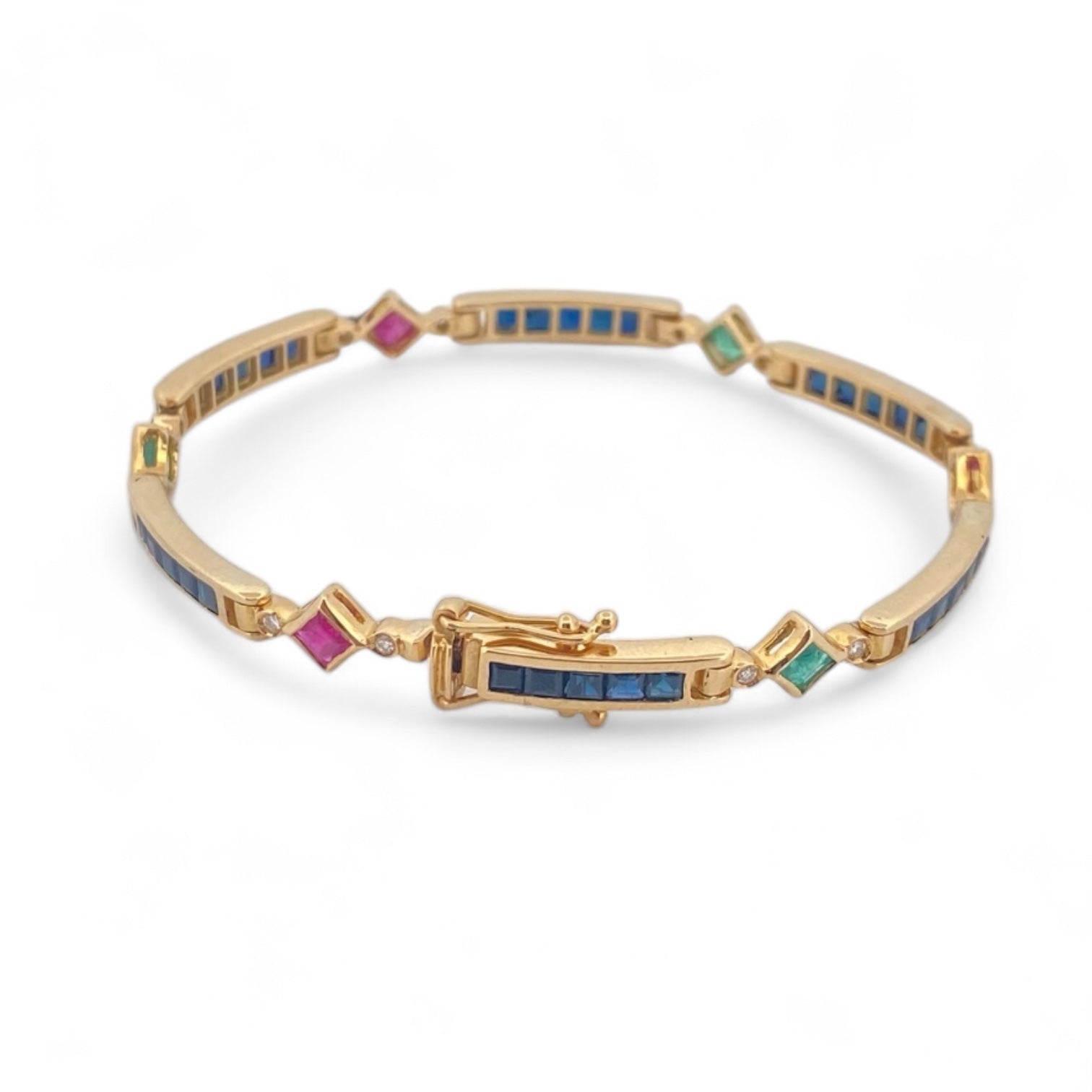 Pulsera semirígida de oro de 18kt con 3 rubíes, 3 esmeraldas y 30 zafiros azules talla princesa. Esta preciosa pulsera vintage dispone de cierre cajón y doble cierre de seguridad. Pesa 13,89g y mide 19cm.