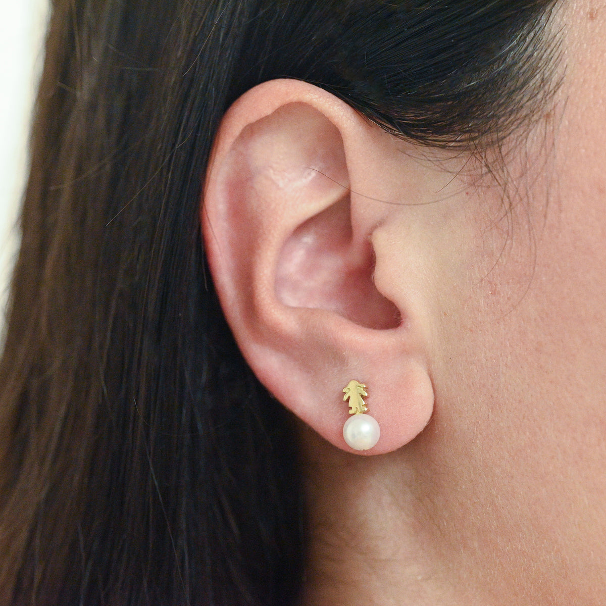 Comprar pendientes originales de la firma TOUS realizados en oro amarillo de 18kt con niñas encima de perlas cultivadas. Con cierre por presión. Joyería Ian'Or.