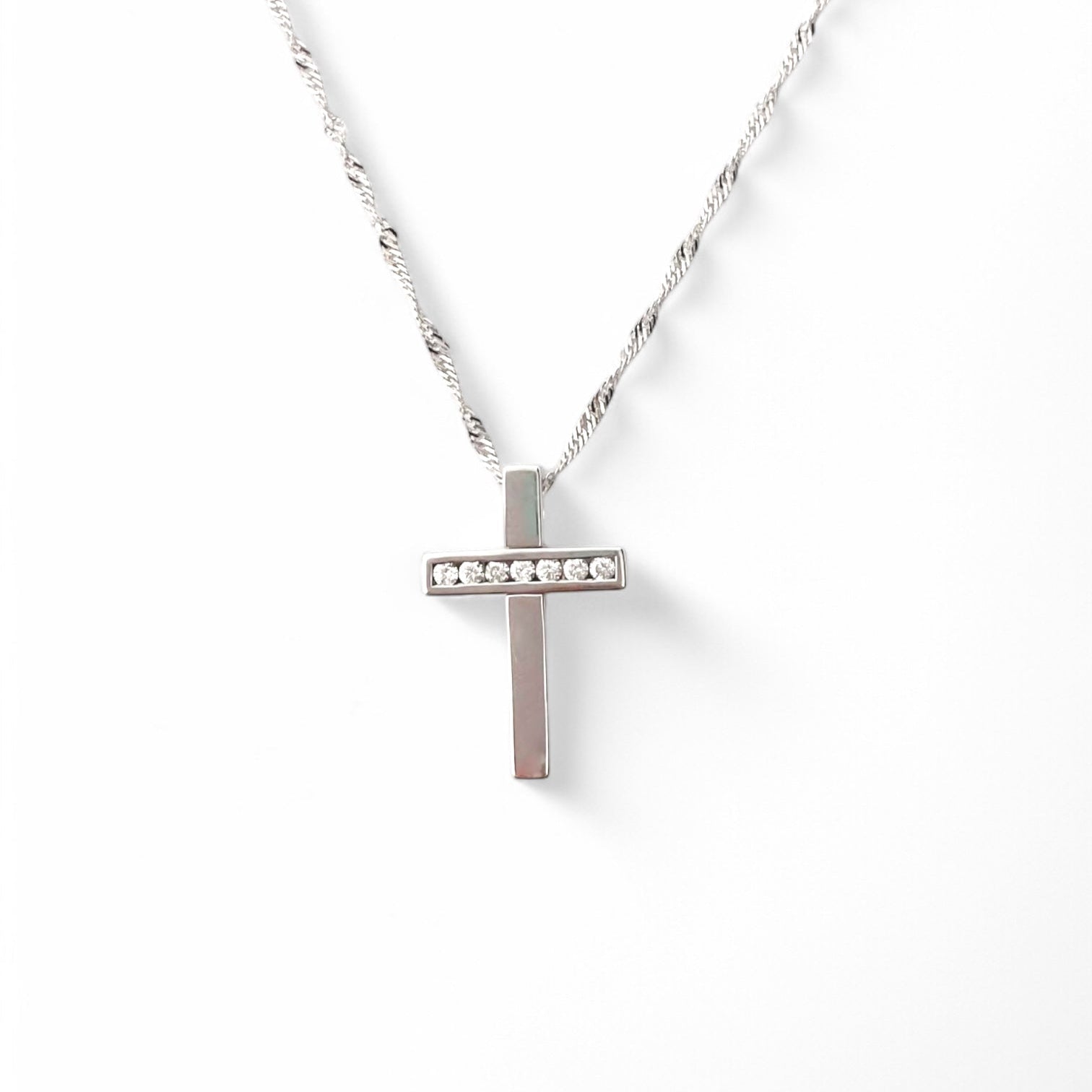 Collar realizado en oro blanco de 18kt compuesto por cadena y cruz con 7 diamantes talla brillante. Cierre tipo mosquetón. Joyería Compro Oro Barcelona.