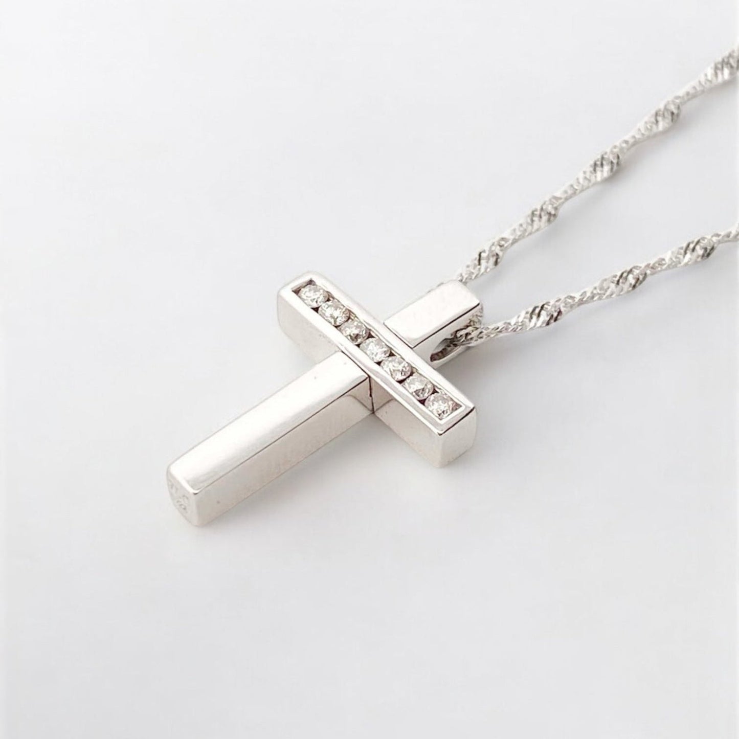 Collar realizado en oro blanco de 18kt compuesto por cadena y cruz con 7 diamantes talla brillante. Cierre tipo mosquetón. Joyería Compro Oro Barcelona.