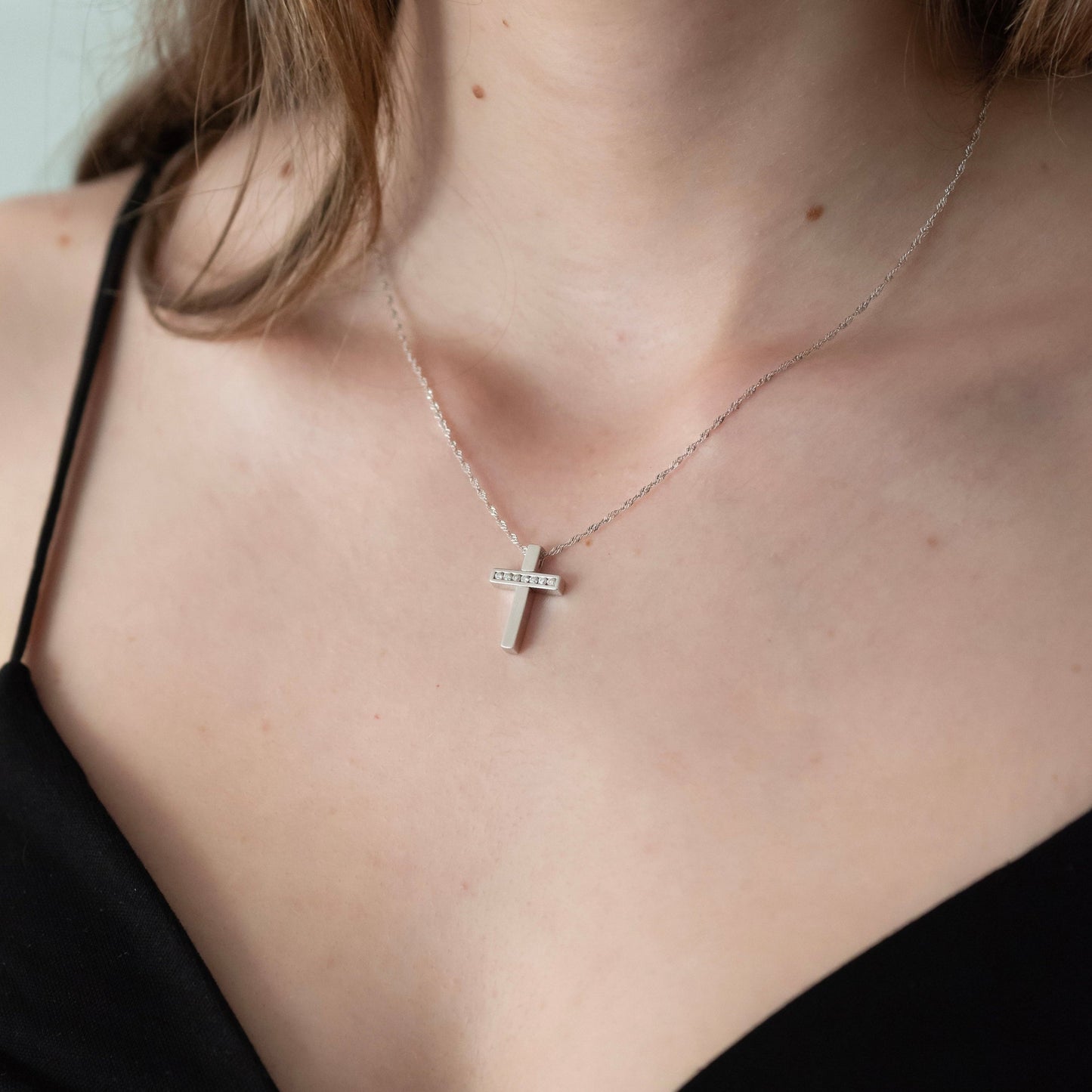 Collar realizado en oro blanco de 18kt compuesto por cadena y cruz con 7 diamantes talla brillante. Cierre tipo mosquetón. Joyería Compro Oro Barcelona.