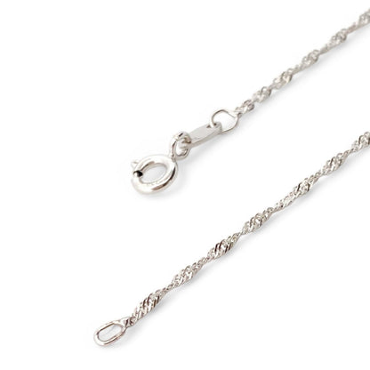 Collar realizado en oro blanco de 18kt compuesto por cadena y cruz con 7 diamantes talla brillante. Cierre tipo mosquetón. Joyería Compro Oro Barcelona.