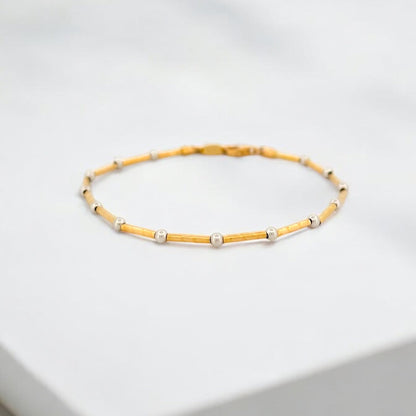 Pulsera de oro amarillo de 18kt con tubitos martilleados y 14 bolitas intercaladas en oro blanco y cierre tipo mosquetón. Pulseras de oro baratas.