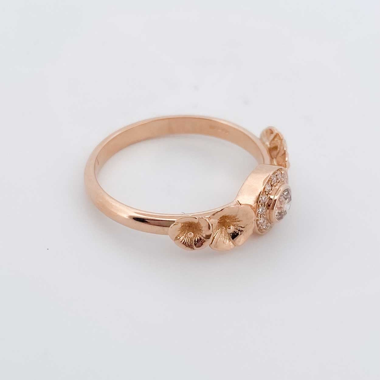 Anillo de Oro rosa de 18kt con 1 diamante central y 14 a su alrededor talla brillante. Con motivos de flores a los lados. Compro oro Barcelona, dónde comprar y vender joyas al mejor precio en Barcelona. Joyas al mejor precio de segunda mano restauradas. Envío gratuito. 