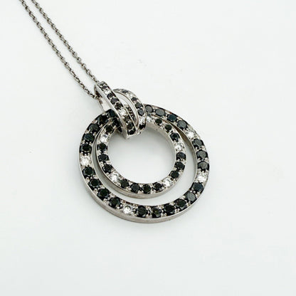Comprar colgante en oro blanco de 18kt en forma de círculos con diamantes negros y blancos. Joyas segunda mano. Joyería Ian'Or.