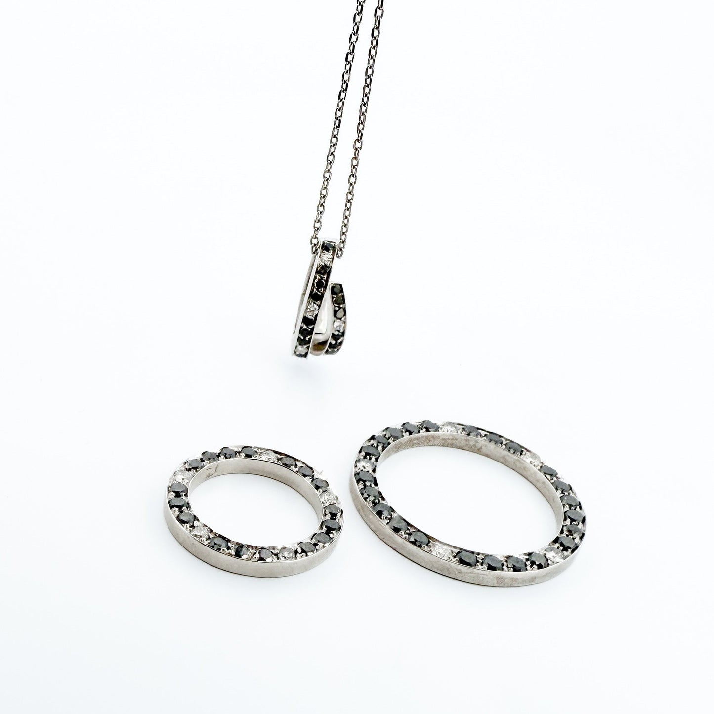 Comprar colgante en oro blanco de 18kt en forma de círculos con diamantes negros y blancos. Joyas segunda mano. Joyería Ian'Or.