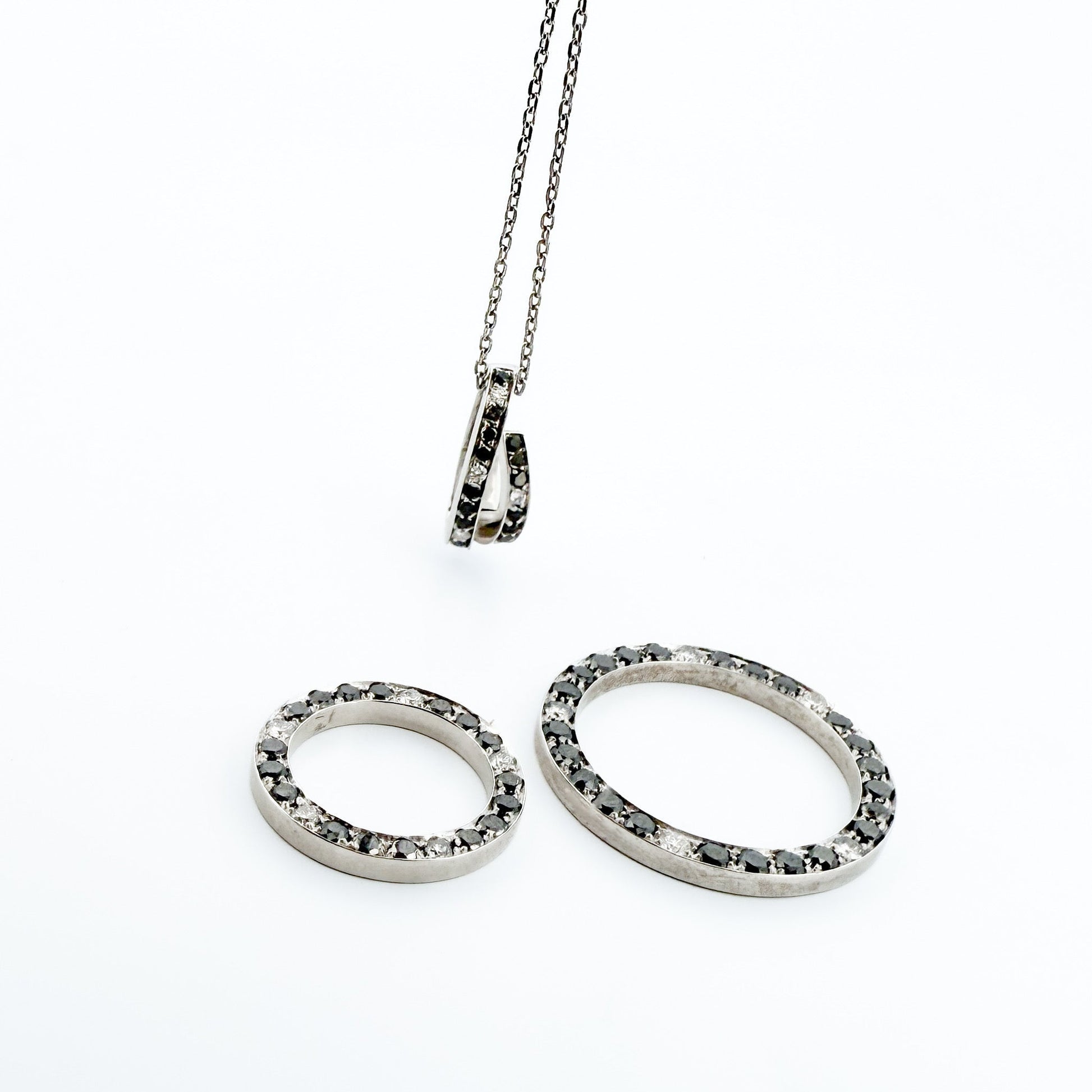 Comprar colgante en oro blanco de 18kt en forma de círculos con diamantes negros y blancos. Joyas segunda mano. Joyería Ian'Or.
