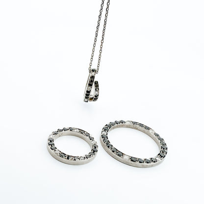 Comprar colgante en oro blanco de 18kt en forma de círculos con diamantes negros y blancos. Joyas segunda mano. Joyería Ian'Or.