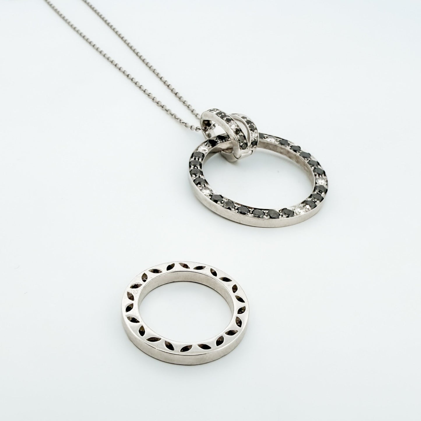 Comprar colgante en oro blanco de 18kt en forma de círculos con diamantes negros y blancos. Joyas segunda mano. Joyería Ian'Or.