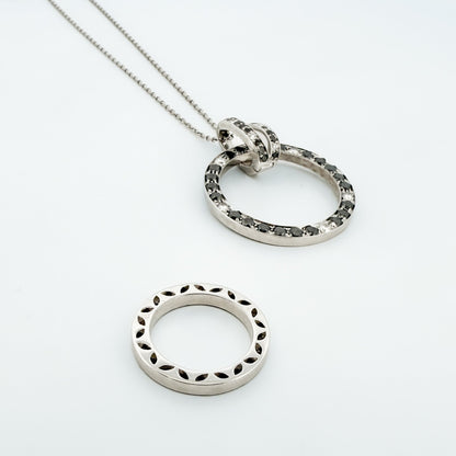 Comprar colgante en oro blanco de 18kt en forma de círculos con diamantes negros y blancos. Joyas segunda mano. Joyería Ian'Or.