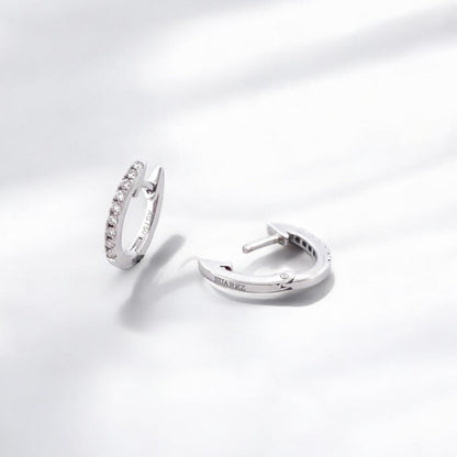 Comprar pendientes Suarez de oro blanco de 18kt en forma de aro pequeño y 9 diamantes talla brillante en cada pendiente. Cierre catalán. Joyería Ian'Or.