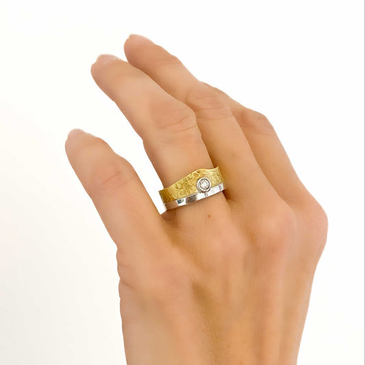 Anillo bicolor de oro blanco y amarillo de 18kt con diamante talla brillante engastado en la parte central. Joyas segunda mano restauradas baratas en Barcelona.