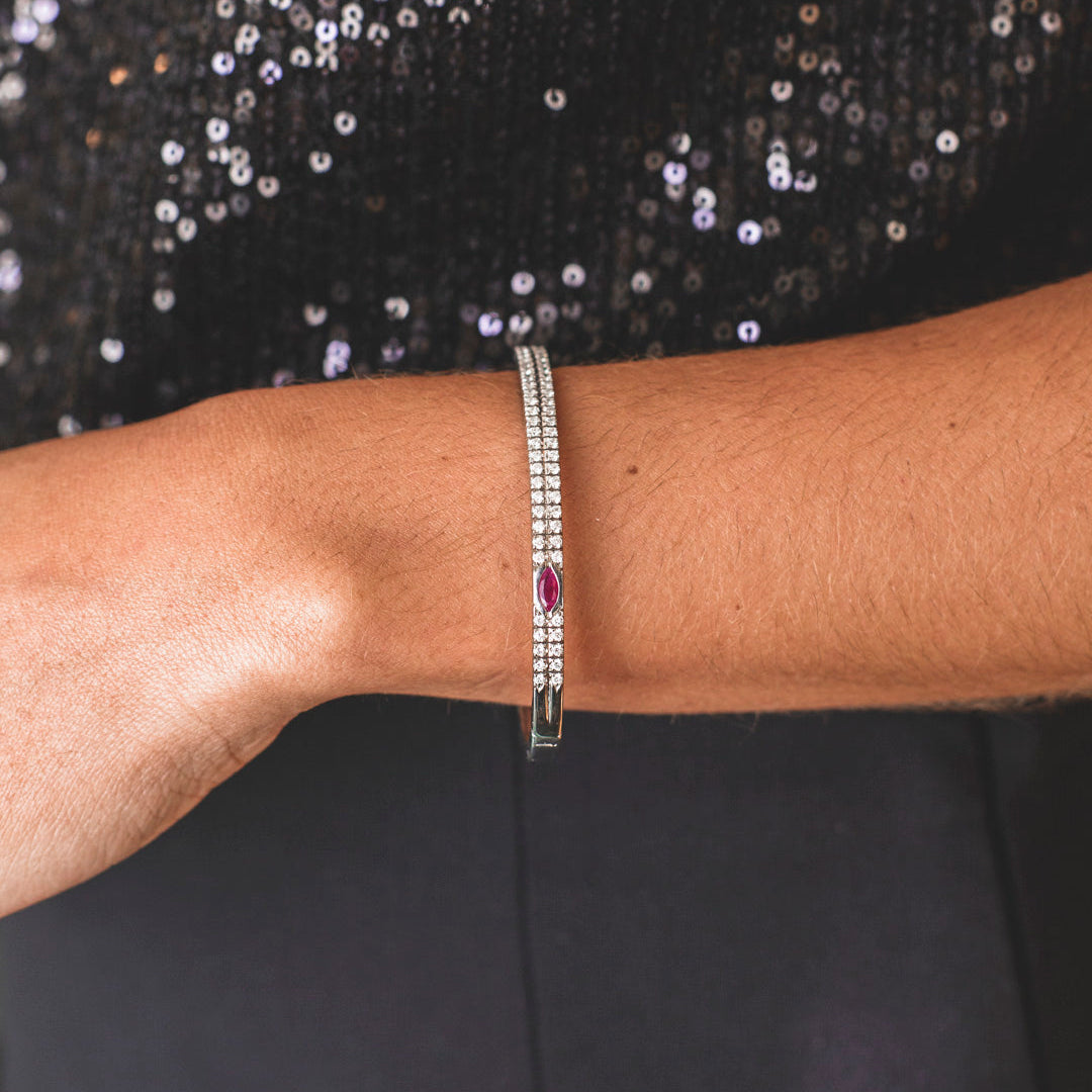 Comprar pulsera esclava realizada en oro blanco de 18kt. Con carril de 58 diamantes talla brillante y dos rubíes. Joyería Ian'Or. Envío gratis.