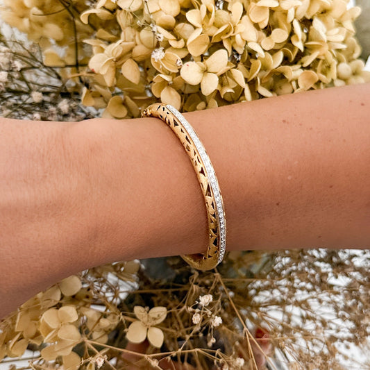 Comprar pulsera esclava de oro amarillo de 18kt en acabado mate y diseño de corazones con carril de oro blanco y 33 diamantes talla brillante. Joyería Ian'Or.