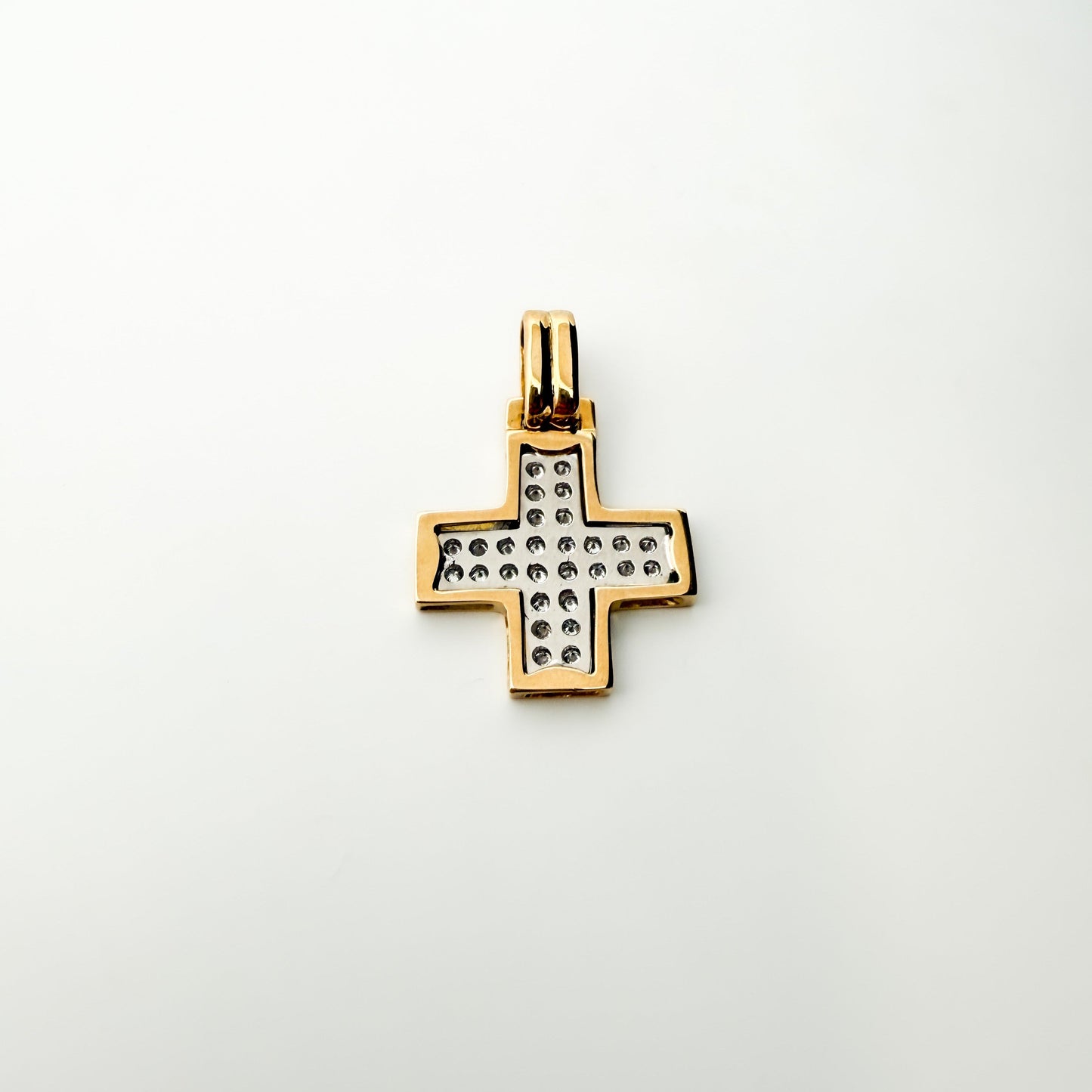 Colgante bicolor en forma de cruz cuadrada realizada en oro amarillo de 18kt con engaste en oro blanco de 28 diamantes talla brillante.
