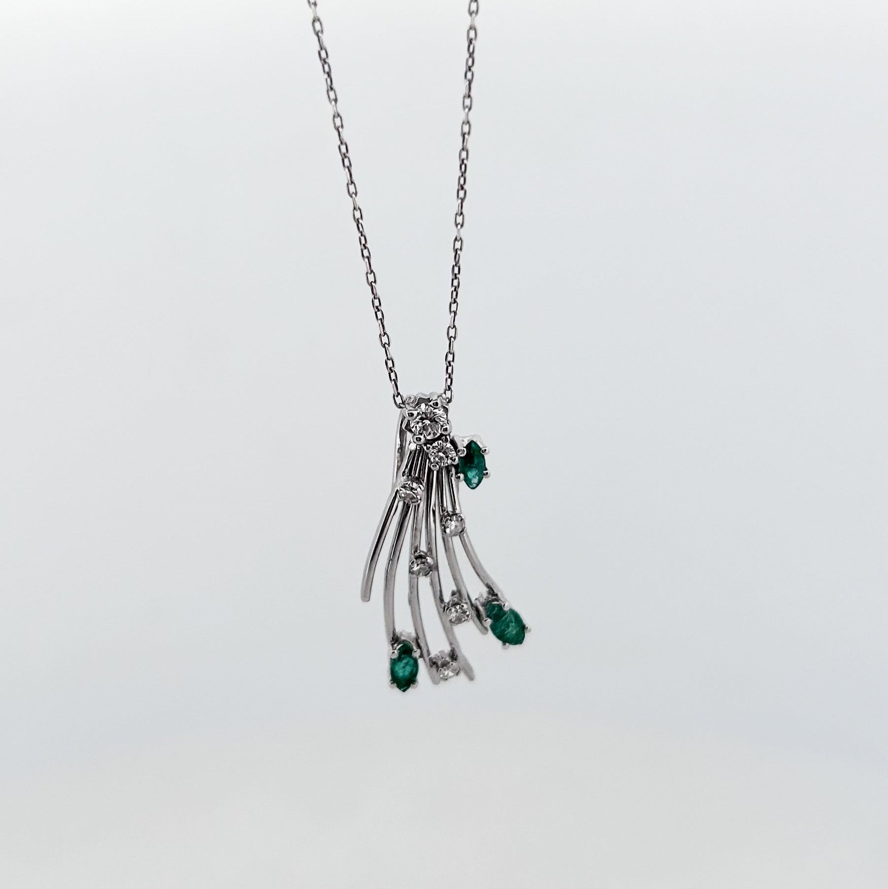 Comprar colgante antiguo de oro blanco 18kt con brillante central engastado en grapas, 6 diamantes a lo largo del abanico y 3 esmeraldas talla marquise.

