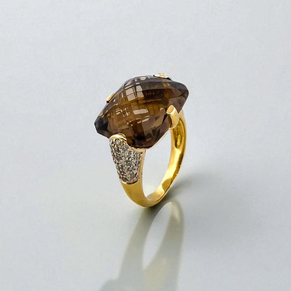 Comprar sortija de oro amarillo de 18kt con piedra central de color café y pavé de diamantes en los brazos. Joyería compro oro Ian'Or. Envío GRATIS.

