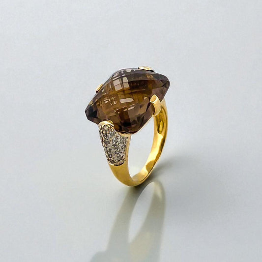 Comprar sortija de oro amarillo de 18kt con piedra central de color café y pavé de diamantes en los brazos. Joyería compro oro Ian'Or. Envío GRATIS.
