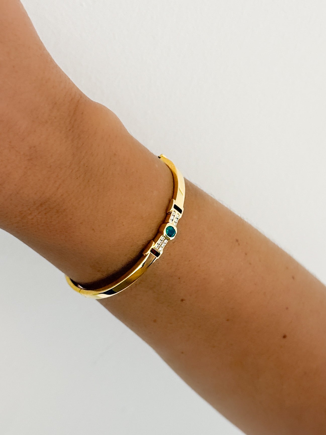 Comprar pulsera tipo esclava de Oro amarillo de 18kt con esmeralda y diamantes. Esta preciosa pulsera rígida dispone de un delicado cierre tipo cajón. Ian'Or.

