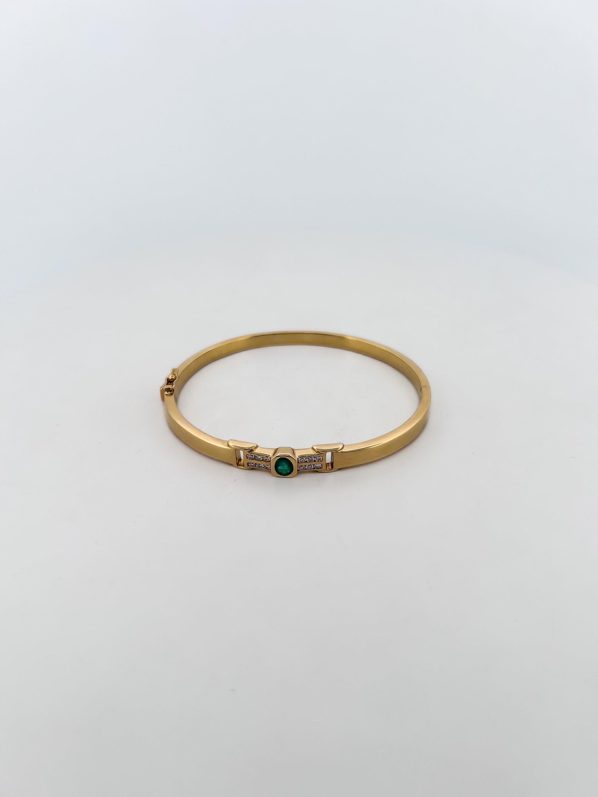 Comprar pulsera tipo esclava de Oro amarillo de 18kt con esmeralda y diamantes. Esta preciosa pulsera rígida dispone de un delicado cierre tipo cajón. Ian'Or.

