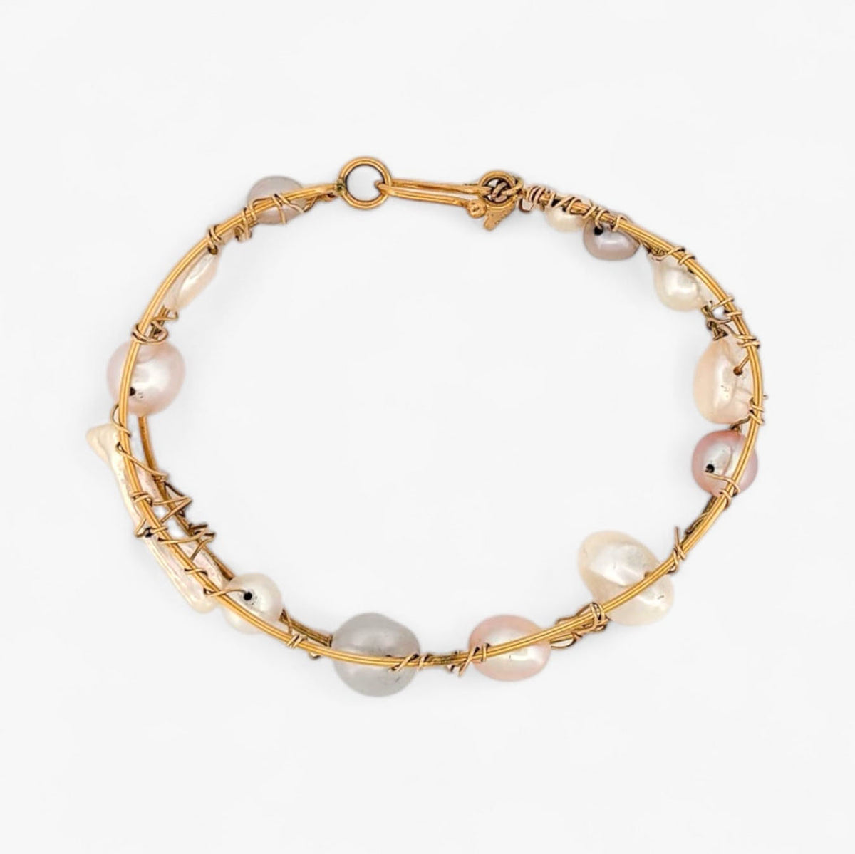 Pulsera original de Tous con perlas de distintos tonos en Oro amarillo de 18kt. La pulsera mide 6,4cm de diámetro y las perlas 12,30mm. Esta pieza ha sido restaurada en nuestro taller de Barcelona. Compro Oro al mejor precio, joyería segunda mano Barcelona, diseño y transformación de joyas.