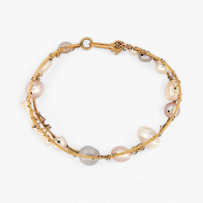 Pulsera original de Tous con perlas de distintos tonos en Oro amarillo de 18kt. La pulsera mide 6,4cm de diámetro y las perlas 12,30mm. Esta pieza ha sido restaurada en nuestro taller de Barcelona. Compro Oro al mejor precio, joyería segunda mano Barcelona, diseño y transformación de joyas.