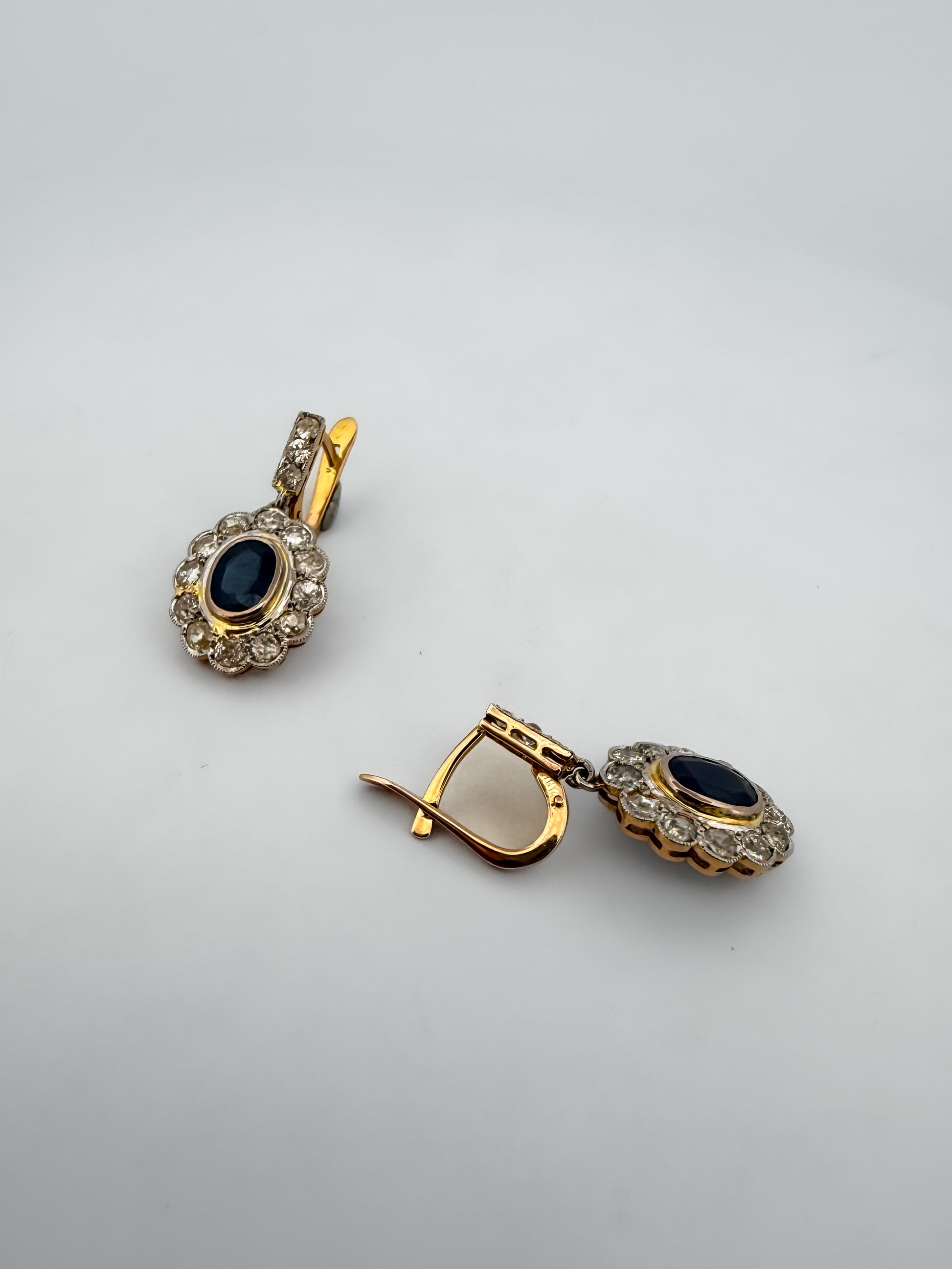 Pendientes vintage de oro amarillo de 18kt  con diamantes talla antigua en platino. Estos maravillosos pendientes antiguos están compuestos por 2 rosetones de platino con engaste en chatón de un zafiro talla oval y orla de 12 diamantes talla antigua cada uno , lo que los convierte en una joya excepcional Cierre catalan