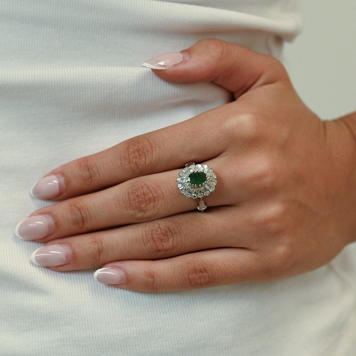 Sortija realizada en oro blanco de 18kt con rosetón de esmeralda talla oval y 2 orlas de brillantes. Rosetones de esmeraldas al mejor precio