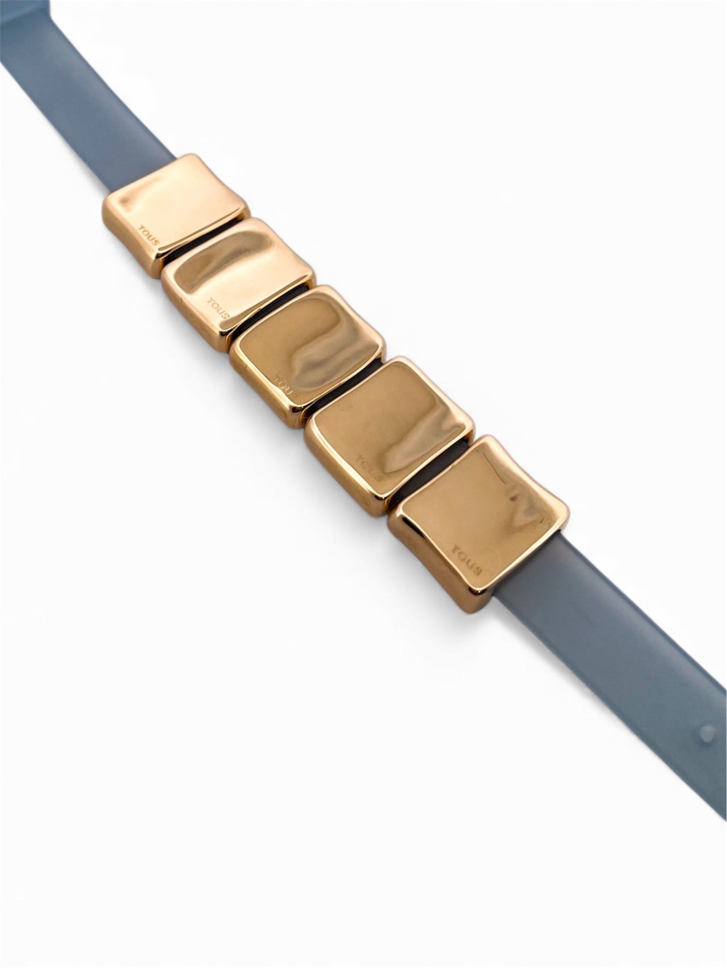 Comprar pulsera de Tous realizada en caucho y con quadrados en el centro realizados en oro amarillo con diferentes dibujos en cada uno. Joyas de Tous de oro descatalogadas al mejor precio