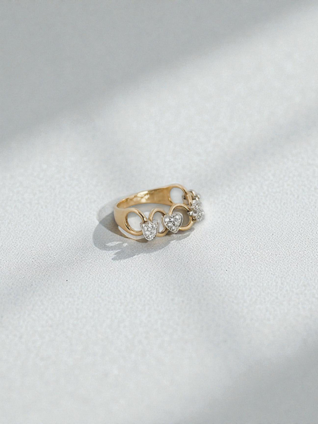 Comprar anillo original de TOUS movil realizado en oro amarillo y con diferentes figuritas como flores, corazones y el iconico oso de la marca, realizados en oro blanco.Joyas Tous baratas.