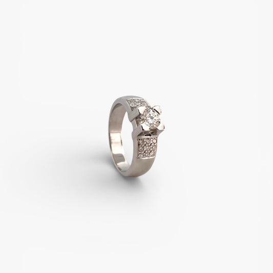 Comprar Anillo en oro blanco de 18kt con un diamante central engastado por 4 grapas y 9 brillantes a cada lado en los brazos. Anillos de diamantes al mejor precio en Barcelona