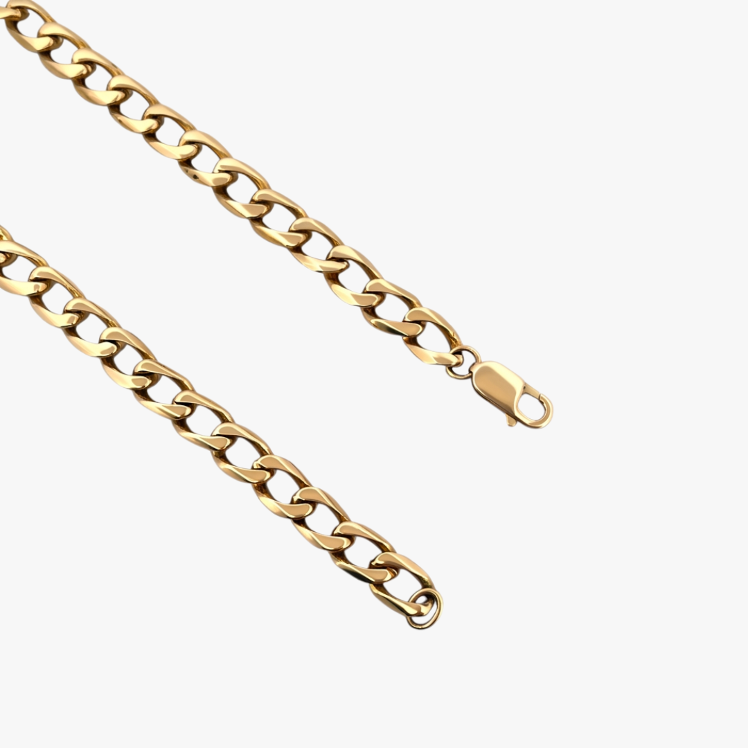 Cadena barbada tipo cubana plana y cierre tipo mosquetón de oro amarillo de 18kt. Si quieres probarte esta pulsera la encontrarás en nuestra tienda de C/ Mallorca, 160 de Barcelona.