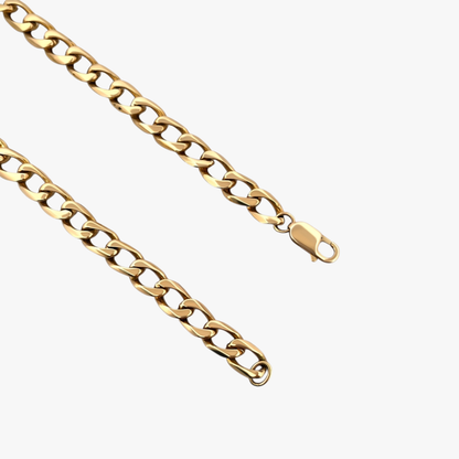Cadena barbada tipo cubana plana y cierre tipo mosquetón de oro amarillo de 18kt. Si quieres probarte esta pulsera la encontrarás en nuestra tienda de C/ Mallorca, 160 de Barcelona.