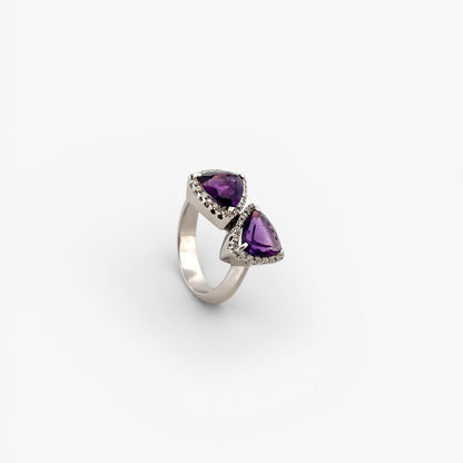 Comprar sortija realizada en oro blanco de 18kt con 2 amatistas cada una en forma de triangulo y 18 diamantes alrededor de cada triangulo. Joyas únicas de segunda mano. Joyería Ian'Or.