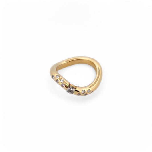 Anillo irregular realizado en oro amarillo de 18kt con diamante central de 0,08ct y 14 diamantes más pequeños a los lados del brazo. Anillos de segunda mano.

