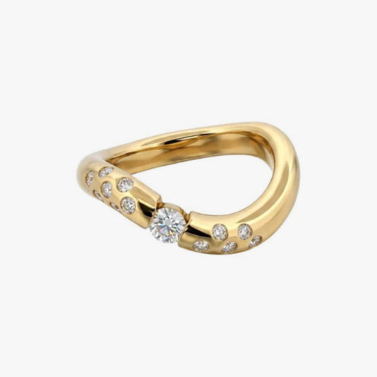 Anillo irregular realizado en oro amarillo de 18kt con diamante central de 0,08ct y 14 diamantes más pequeños a los lados del brazo. Anillos de segunda mano.
