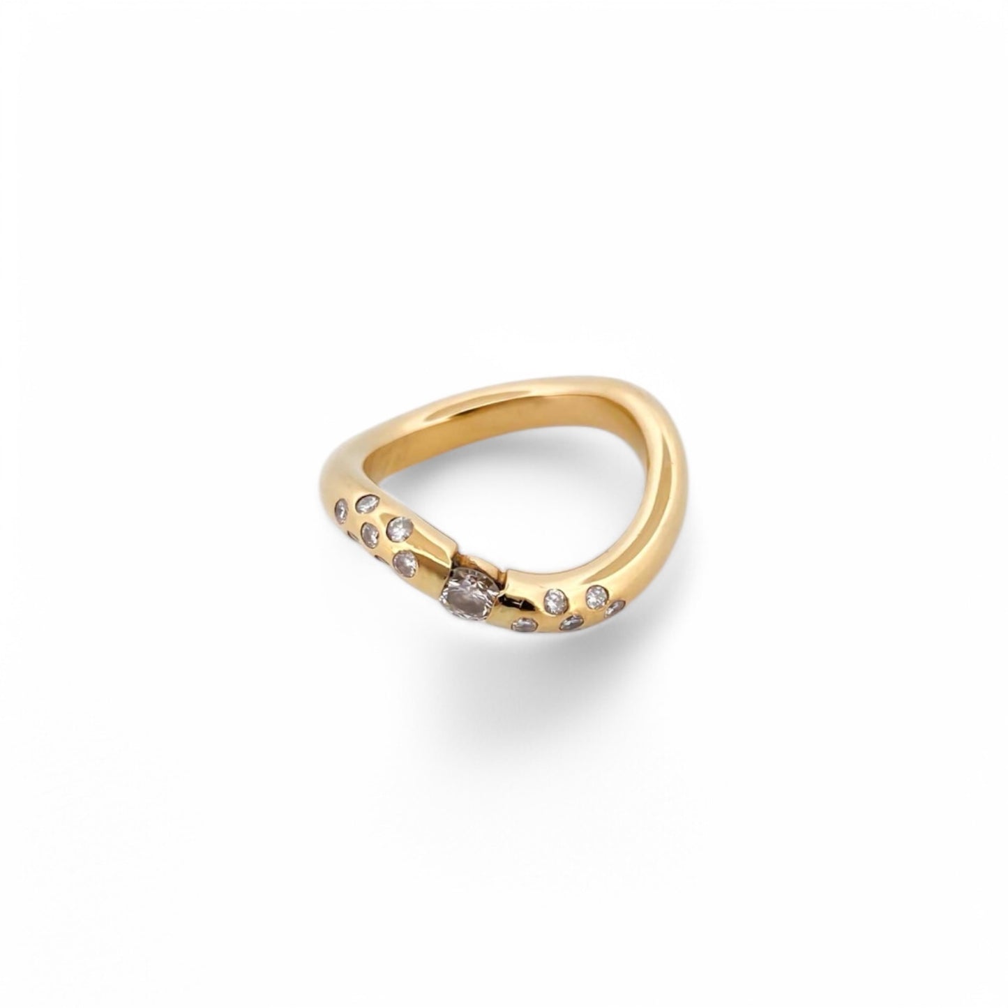 Anillo irregular realizado en oro amarillo de 18kt con diamante central de 0,08ct y 14 diamantes más pequeños a los lados del brazo. Anillos de segunda mano.
