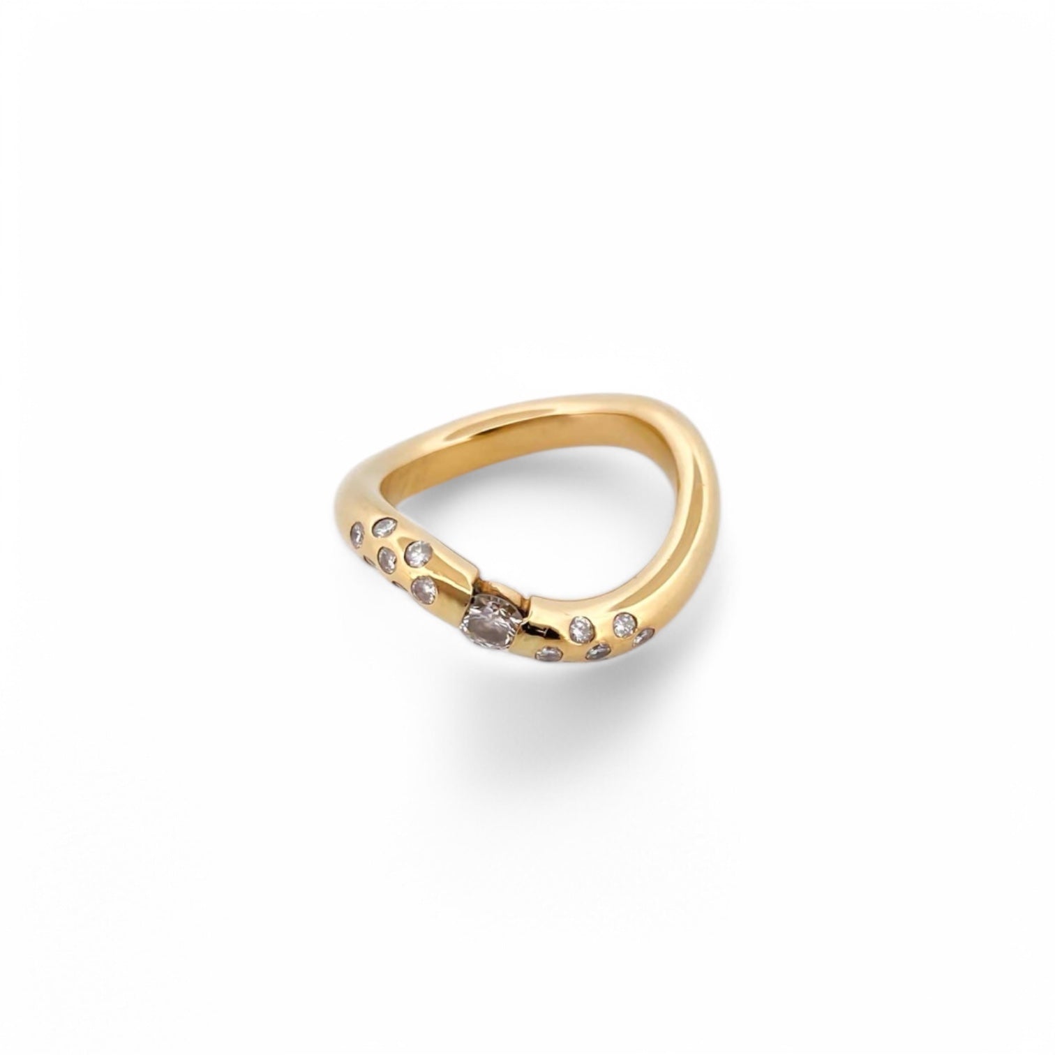 Anillo irregular realizado en oro amarillo de 18kt con diamante central de 0,08ct y 14 diamantes más pequeños a los lados del brazo. Anillos de segunda mano.
