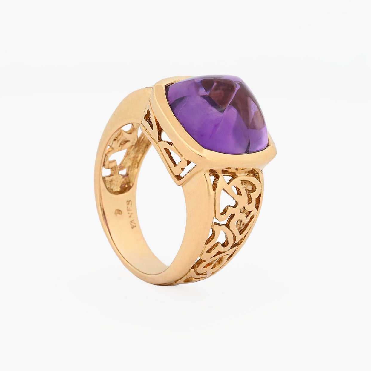Comprar anillo ancho de oro amarillo de 18kt y amatista cabujon en forma de piramide, montada en un aro semicalado con formas de corazon. 