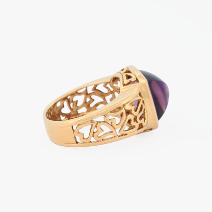 Comprar anillo ancho de oro amarillo de 18kt y amatista cabujon en forma de piramide, montada en un aro semicalado con formas de corazon. 
